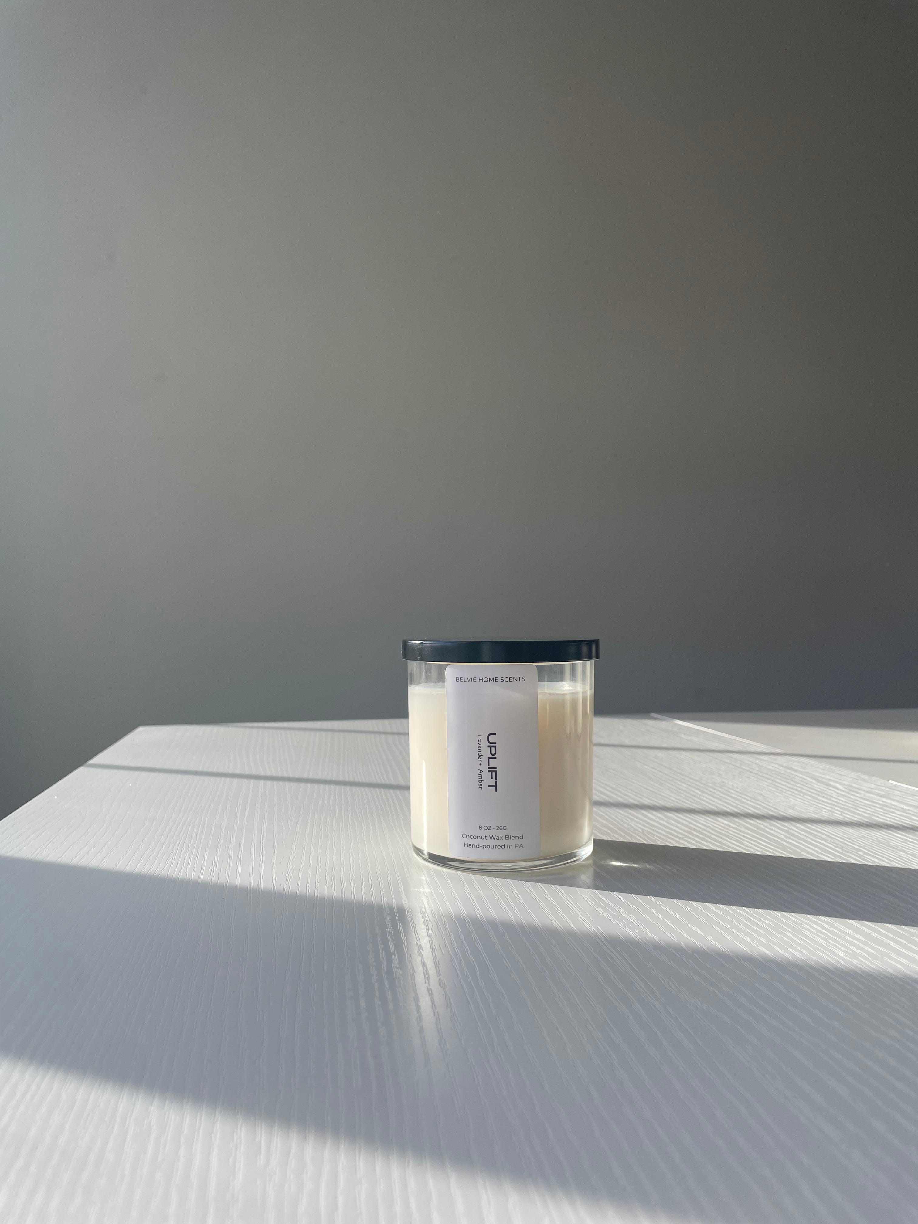 Candle with a label on a textured surface and gray background